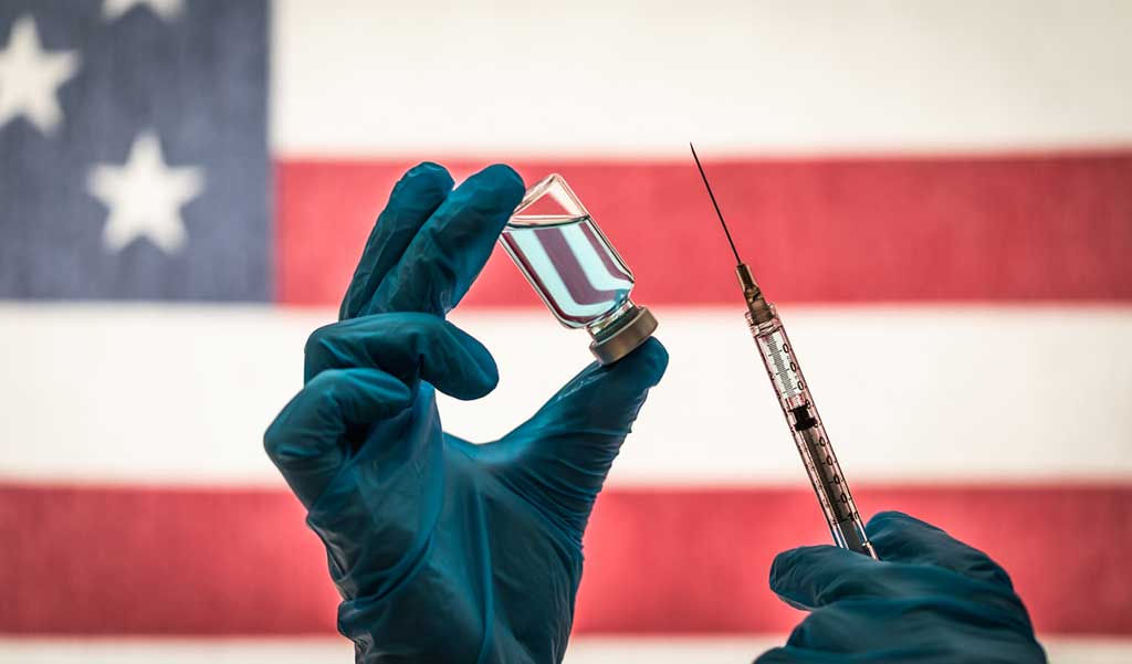 Seringue vaccinale sur fond de drapeau américain symbolisant l'origine américaine des vaccins anti-COVID et l'opération