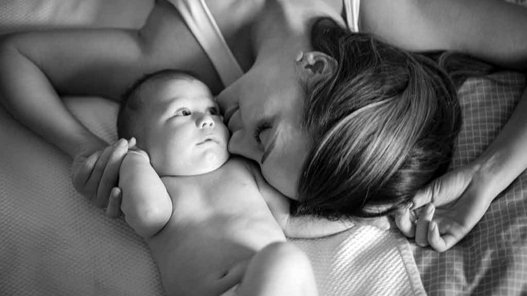 Un bébé, le regard inquiet, et sa mère
