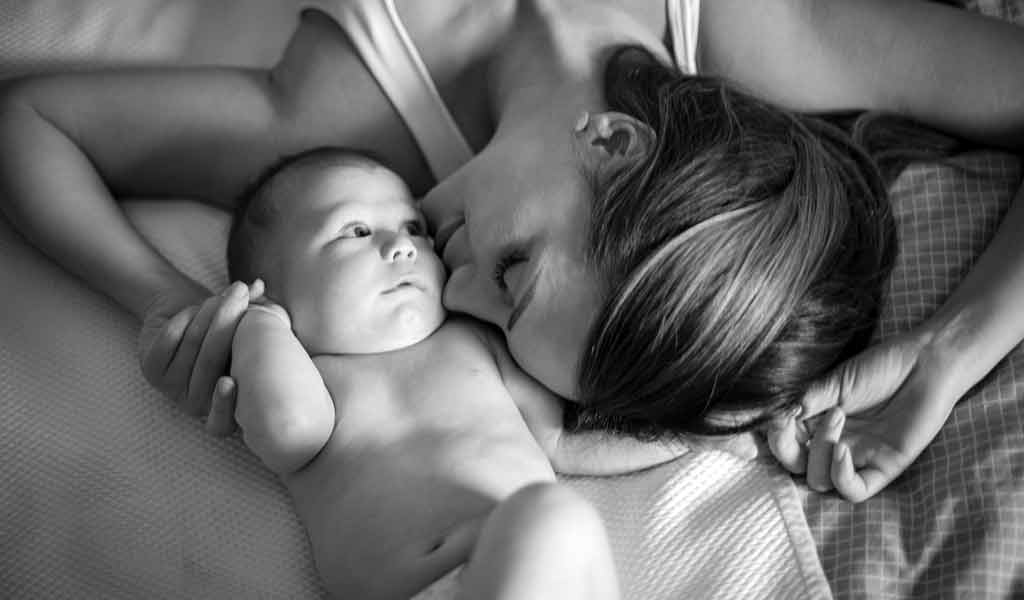 Un bébé, le regard inquiet, et sa mère